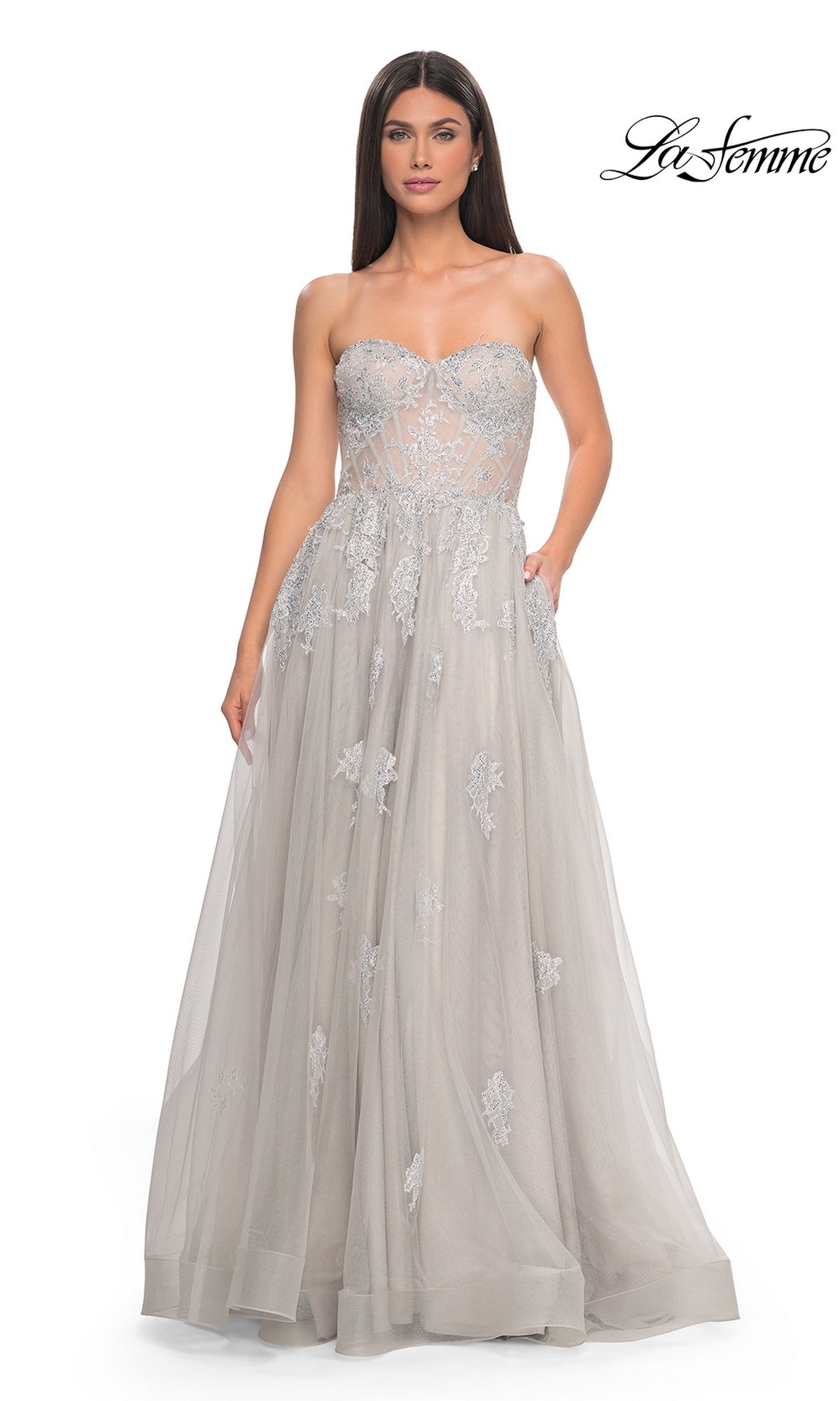 A woman wears the La Femme Strapless Long A-Line Prom Dress 32111 in light gray, featuring embroidered lace appliques and a sheer bodice. The La Femme logo is shown in the top right corner.